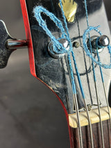 Close-up of a guitar's headstock with tuning pegs and strings.