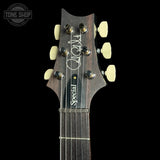 Close-up of the headstock of a dark wood electric guitar, showing six cream-colored tuning pegs, a black string tree, and the words 'Special' in script. A circular 'TONE SHOP' watermark is visible in the top left corner.