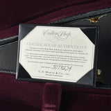 A framed Certificate of Authenticity plaque inside a black guitar case, set against a dark burgundy velvet background. The certificate is from Custom Looph and C.