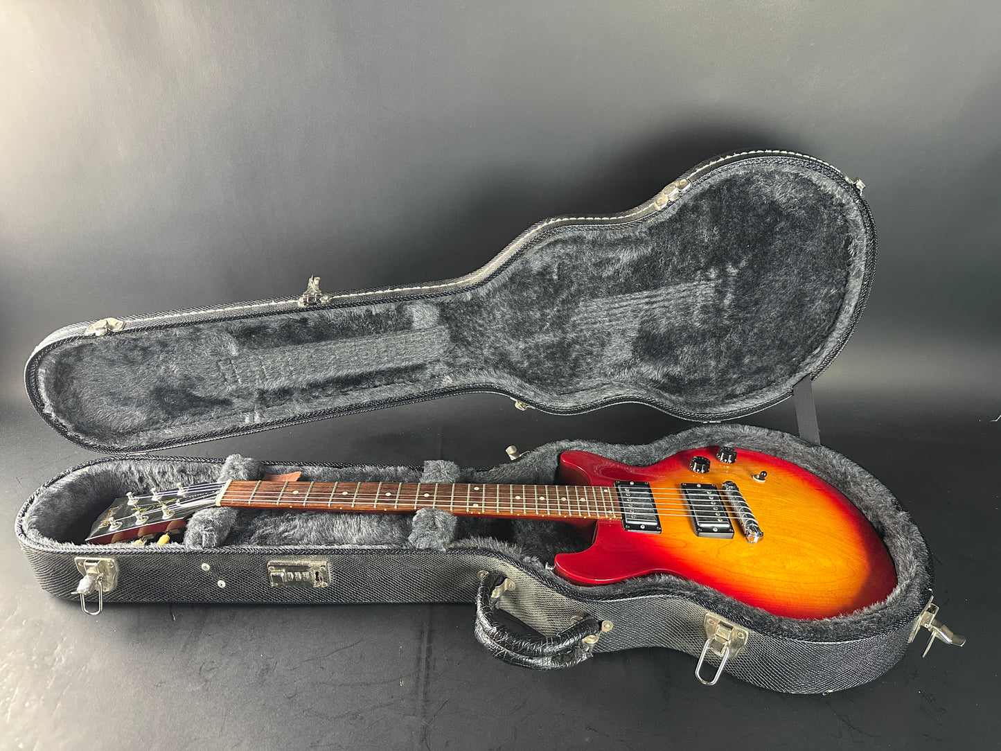 Electric guitar in a hard-shell case on a gray background