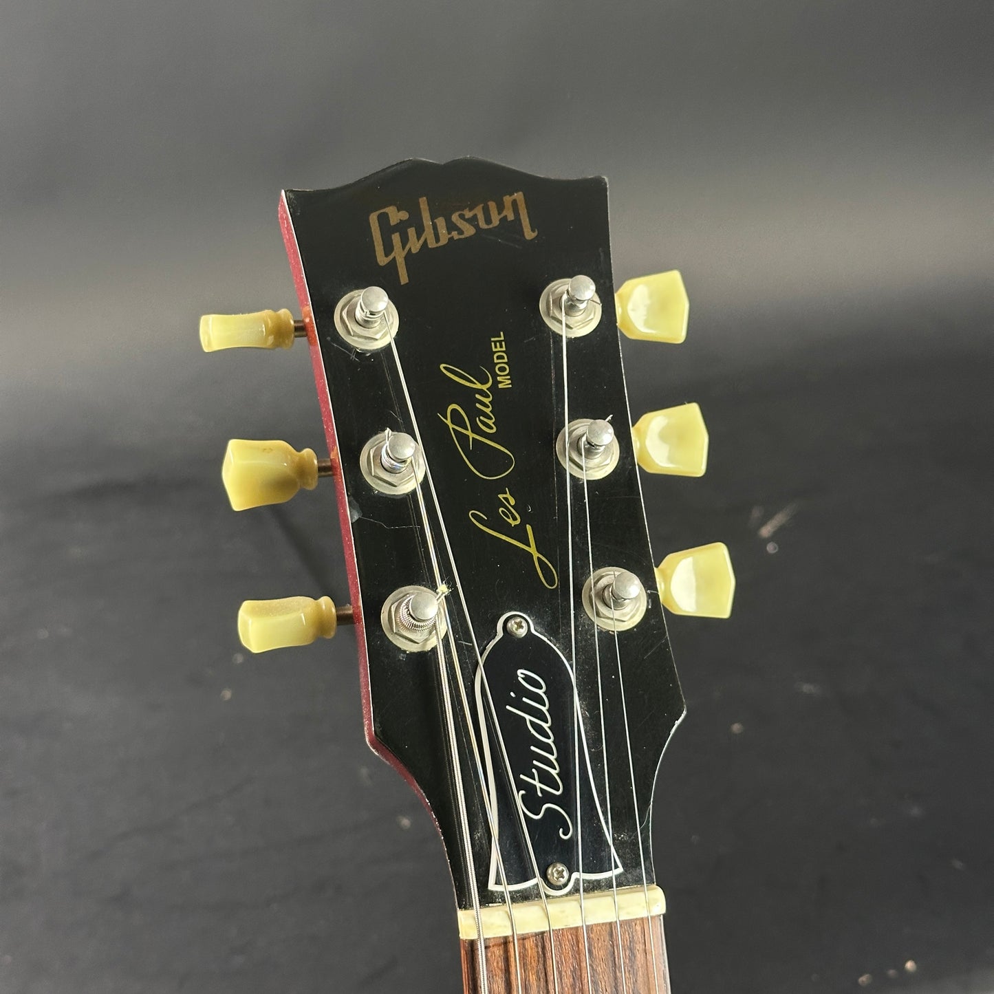 Gibson Les Paul Studio headstock on a dark background