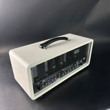 White guitar amplifier with a handle on a dark background