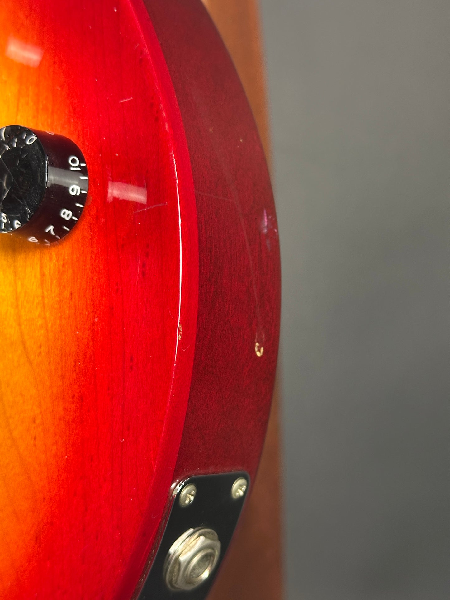 Wear on side edge of Used 1997 Gibson Les Paul Studio Double Cut Cherry Sunburst.