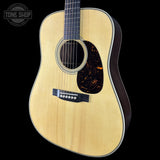Acoustic guitar with a visible brand logo on a black background