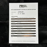 A white printed specification card for the PRS Custom 24 Limited Edition, featuring black text and hand-written details, photographed on a dark textured background.