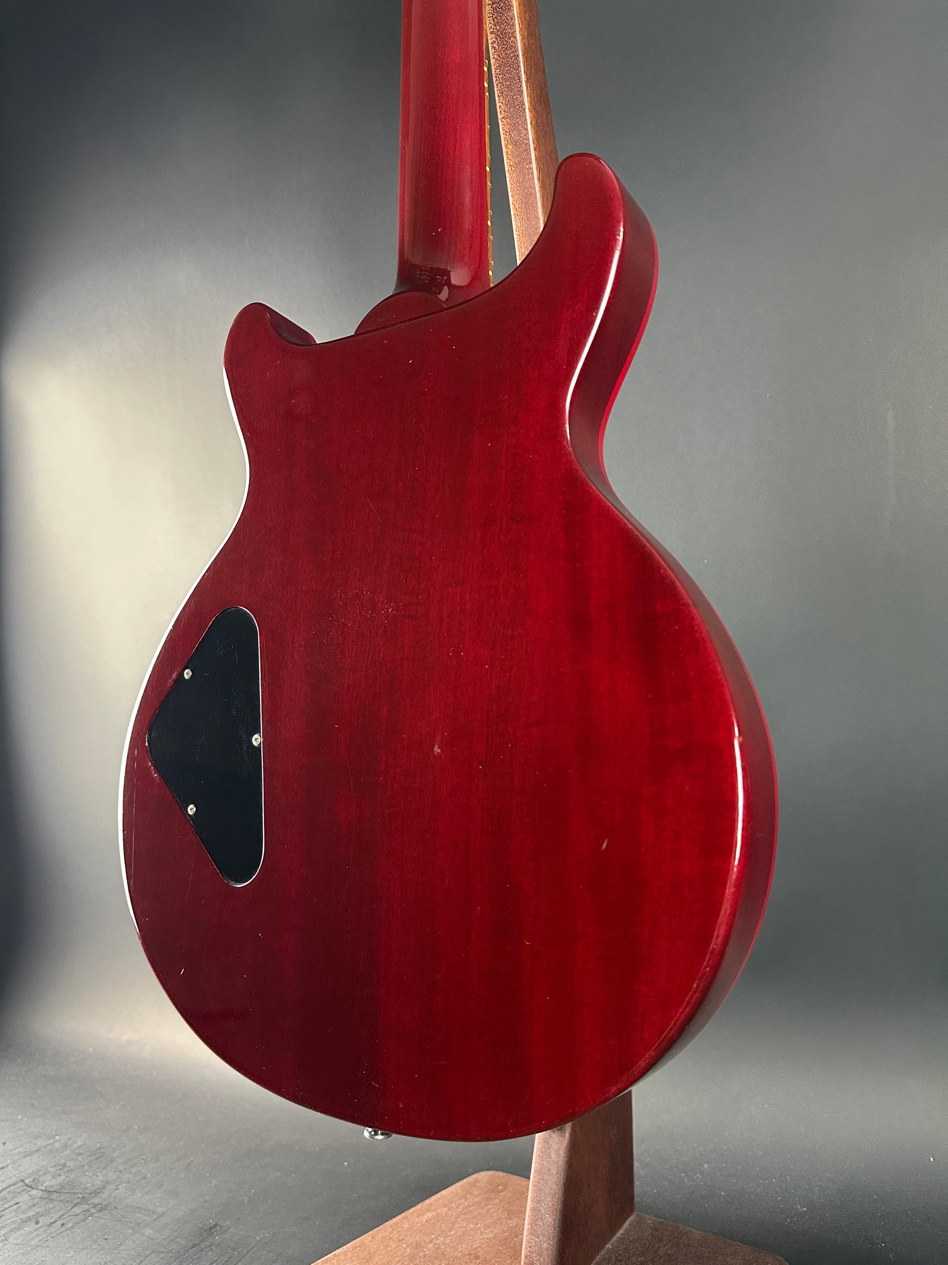 Close-up of a red electric guitar body on a gray background