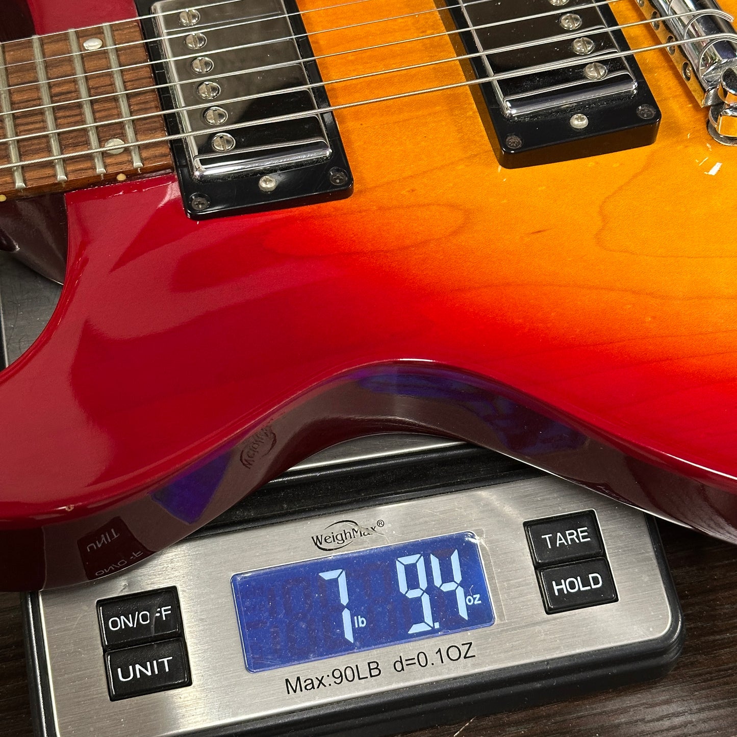 Guitar on a digital scale displaying weight