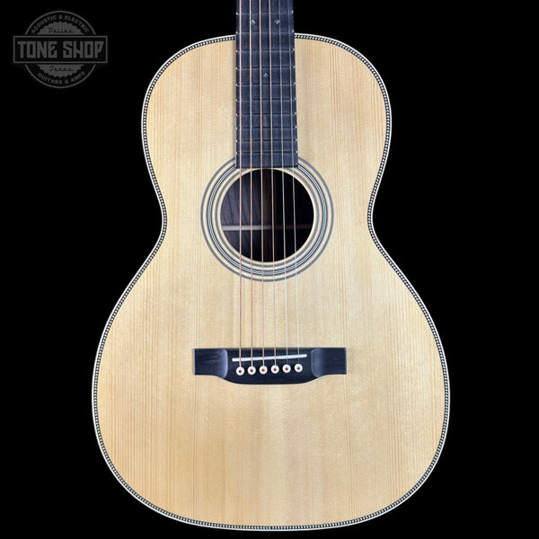 Acoustic guitar with a visible brand logo on a black background