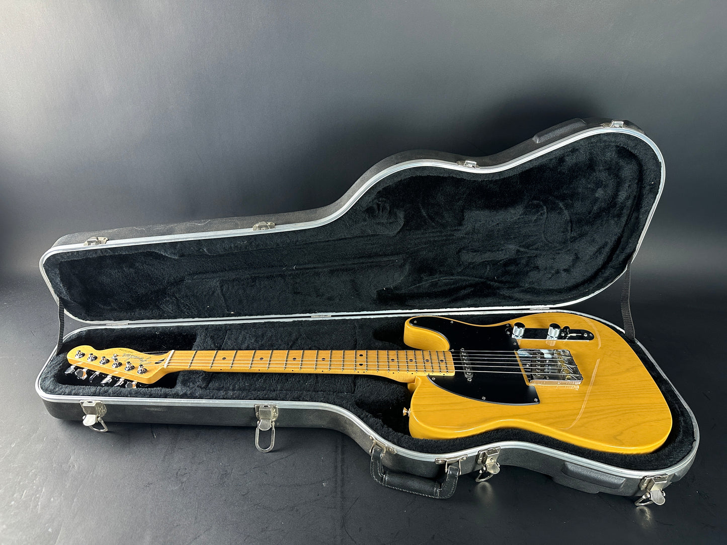 Yellow electric guitar in a black case on a dark background