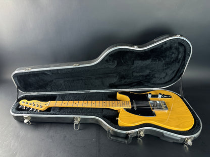 Yellow electric guitar in a black case on a dark background