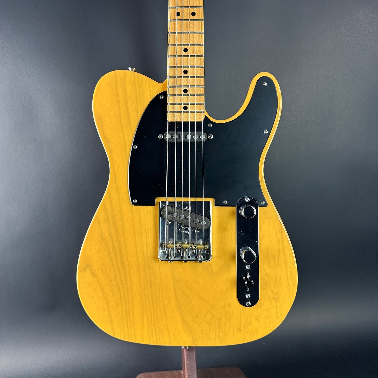 Yellow electric guitar on a gray background