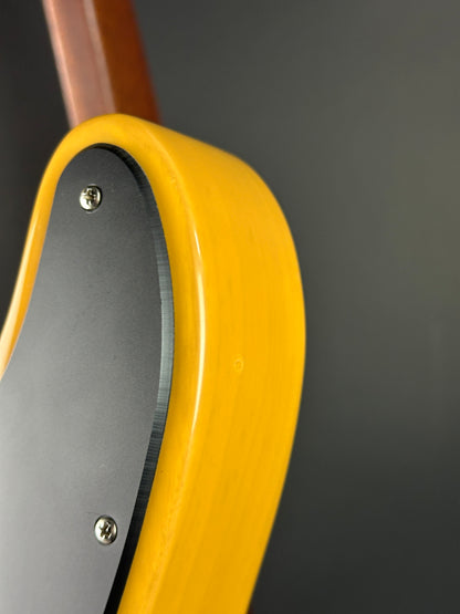 Close-up of a guitar's soundhole with a yellow pickguard on a dark background