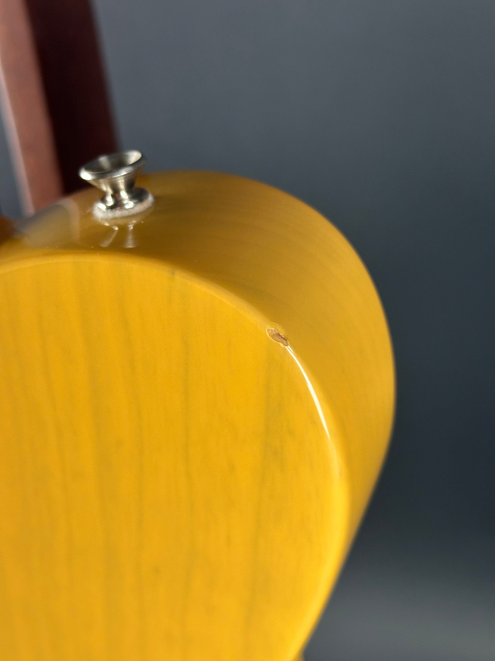 Close-up of a yellow object with a metallic component on a dark background