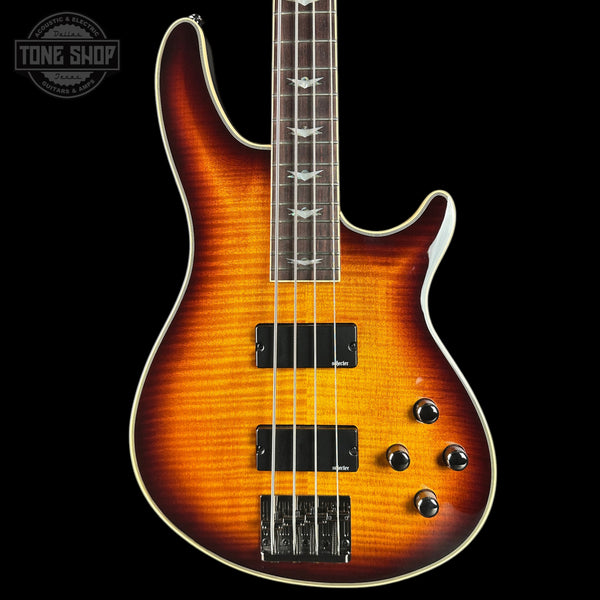 Electric bass guitar with a sunburst finish on a black background, featuring the Tone Shop logo.