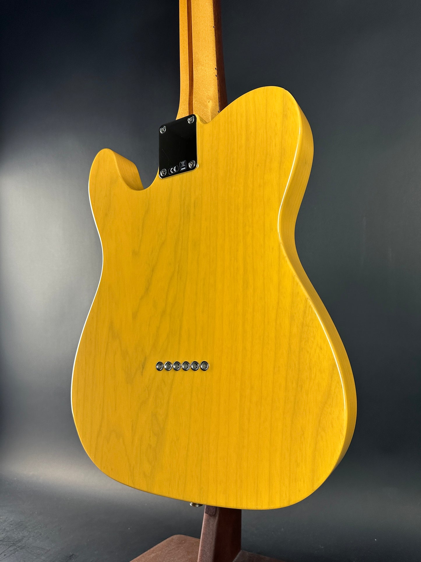 Yellow electric guitar body on a dark gray background