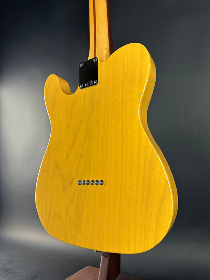 Yellow electric guitar body on a dark gray background