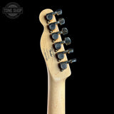 Close-up rear view of a Fender electric guitar headstock in natural maple wood, showing six black tuning pegs with gold accents and the Fender logo printed on the back, set against a solid black background.