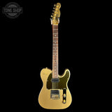 A gold-finished electric guitar with a black pickguard and maple neck, shown against a solid black background. A 'TONE SHOP' watermark is visible in the top-left corner.