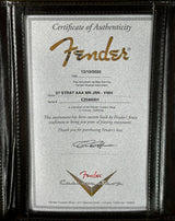 Fender certificate of authenticity in a black leather case on a gold surface