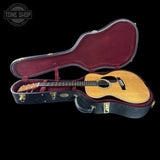 Acoustic guitar in a hard-shell case with 'Tone Shop' logo in the corner.