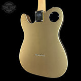 The back of a gold-finished electric guitar body, photographed against a solid black background. A Tone Shop watermark is visible in the top-left corner.