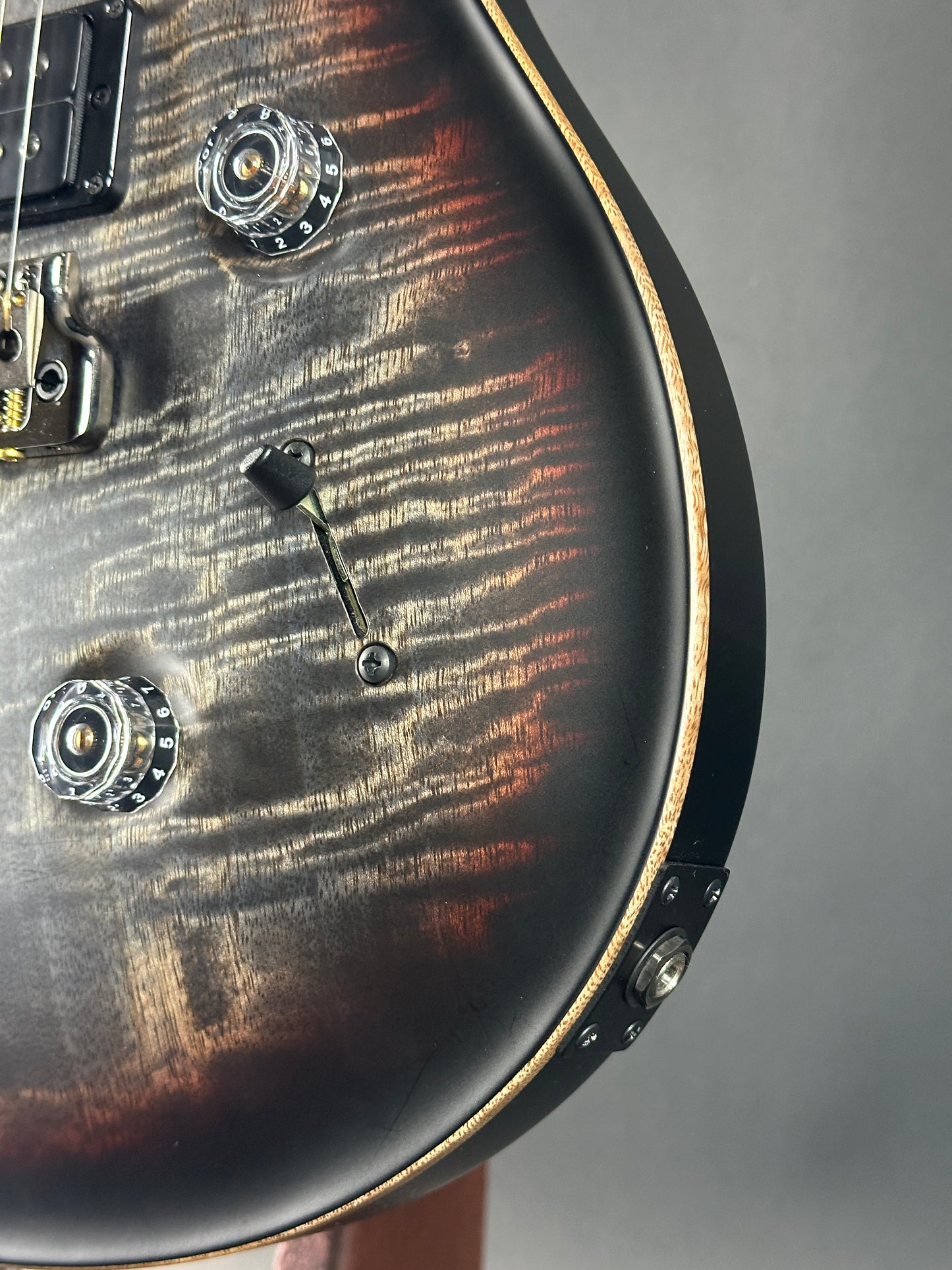 Close-up of a guitar's control knobs on a gray background
