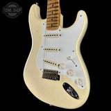 White electric guitar with a black pickguard on a black background, featuring 'Tone Shop' logo.