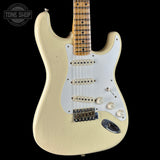White electric guitar with a black background