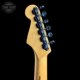 Close-up of the headstock of a Fender electric guitar, showing the natural maple wood neck and dark blue tuners against a solid black background.