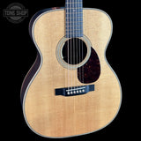 Acoustic guitar with a visible brand logo in the corner