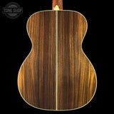 Wooden acoustic guitar back with a visible brand logo in the corner.