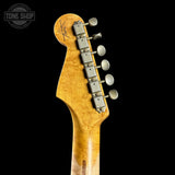 Close-up of a guitar headstock with tuning pegs on a black background, featuring the Tone Shop logo.