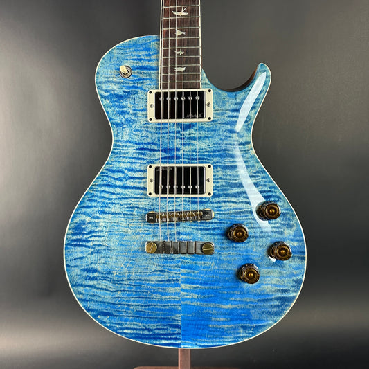 Blue electric guitar with a textured finish on a gray background