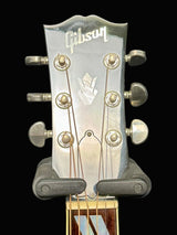 Gibson guitar headstock with tuning pegs on a dark background