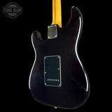 The back view of a black electric guitar with a yellow maple neck, shown against a solid black background. A Tone Shop logo is visible in the top left corner.