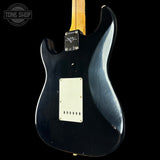 Back view of a black electric guitar with a visible brand logo on a black background
