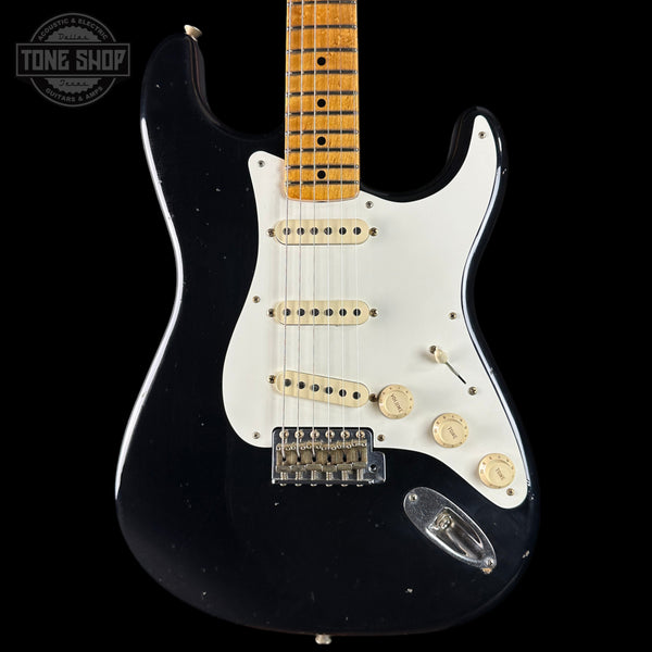 Black electric guitar with a white pickguard on a black background, featuring 'Tone Shop' branding.