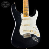 Black electric guitar with a white pickguard on a black background, featuring the Tone Shop logo.