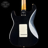 Black electric guitar body with a visible brand logo on a black background
