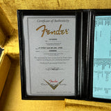 Fender certificate of authenticity inside a guitar case on a gold background
