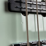 Close-up of a guitar's headstock and strings on a light gray background