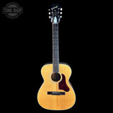 Acoustic guitar with a visible brand logo on a black background