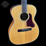 Acoustic guitar with a visible brand logo on a black background