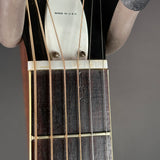 Close-up of a guitar's headstock and strings on a gray background