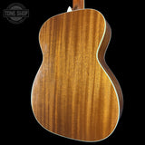 Back view of a wooden acoustic guitar with 'Tone Shop' logo.