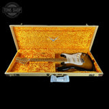 Electric guitar in a yellow case with a visible brand logo, on a black background.