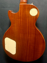 Wooden guitar body with a dark background