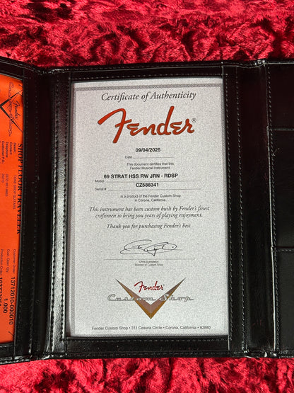 Fender certificate of authenticity inside a leather wallet on a red textured surface