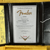 Fender certificate of authenticity in a black leather holder on a gold surface