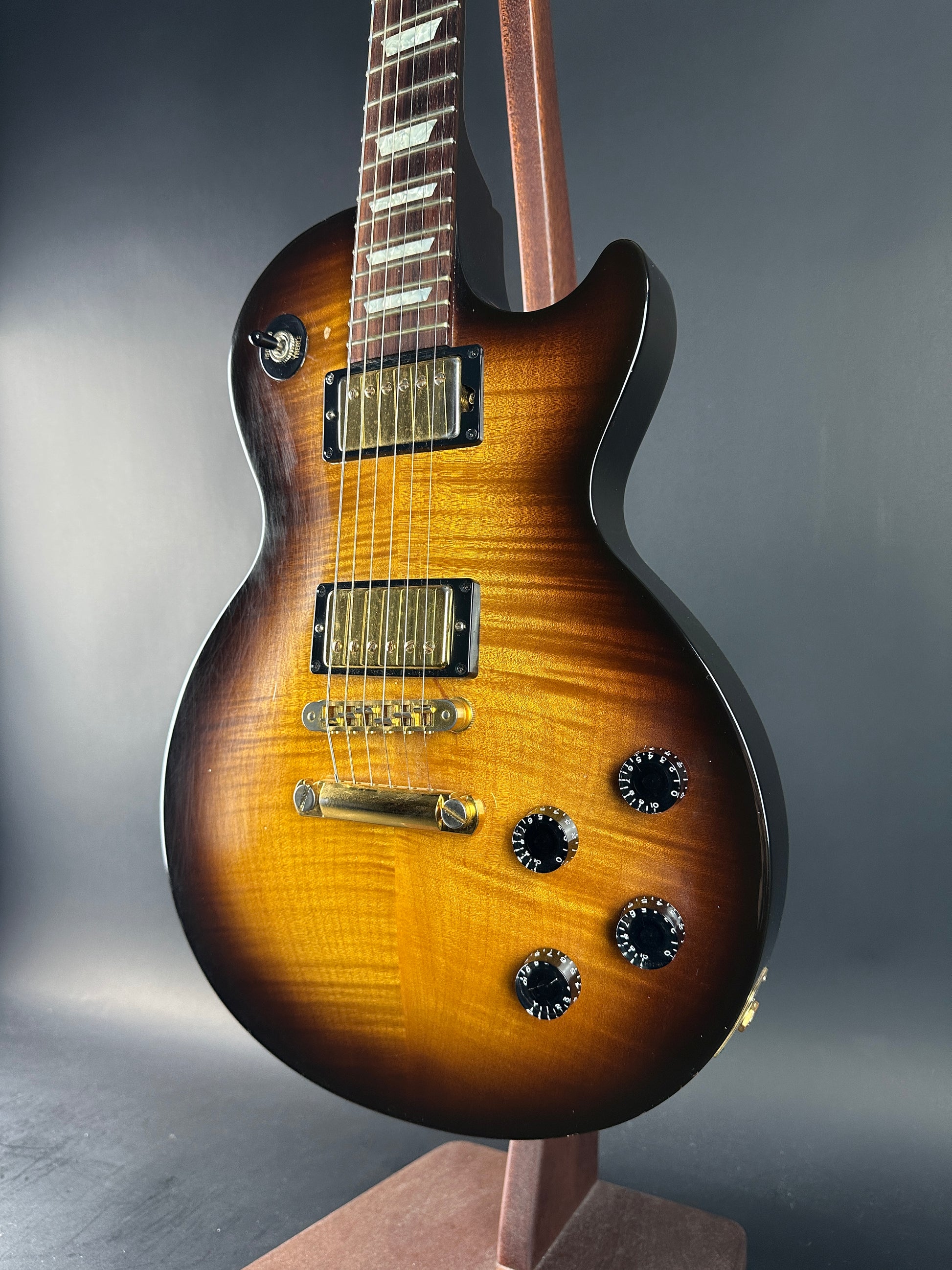 Close-up of a sunburst electric guitar on a gray background
